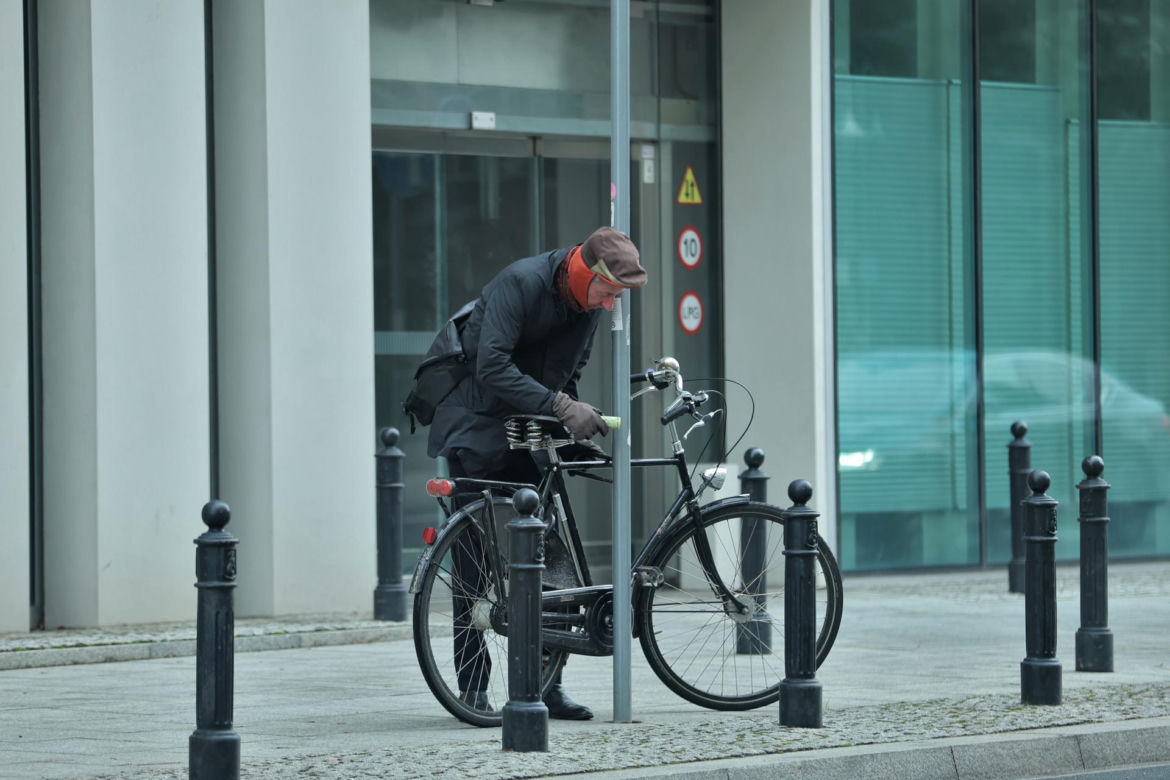 Maciej Gdula na rowerze. Chroni uszy przed chłodem