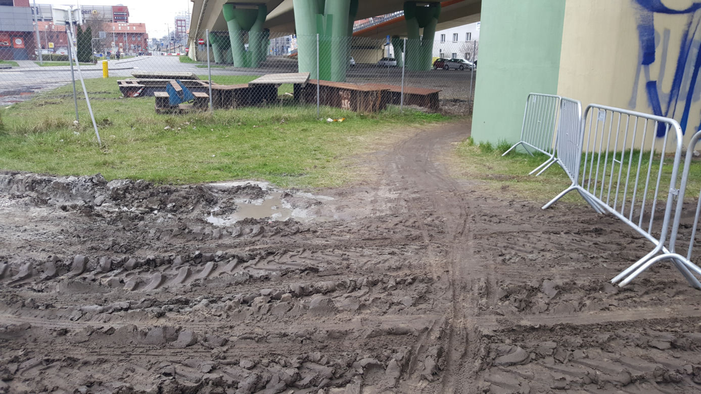 Piesi brodzą w błocie pod Mostem Uniwersyteckim w Bydgoszczy