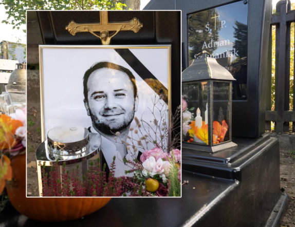 Grób Adriana Szymaniaka miesiąc po jego tragicznej śmierci. Jest złoty krzyż, tymczasowy nagrobek i mnóstwo jesiennych kwiatów