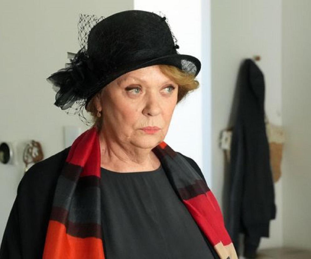 Józefina (Elżbieta Jarosik) z serialu Barwy szczęścia w czarnym żałobnym stroju z kapeluszem i woalką oraz czerwono-czarnym szalikiem, w geście pożegnania z przeszłością przed podpisaniem umowy sprzedaży stadniny. Więcej na Super Seriale.