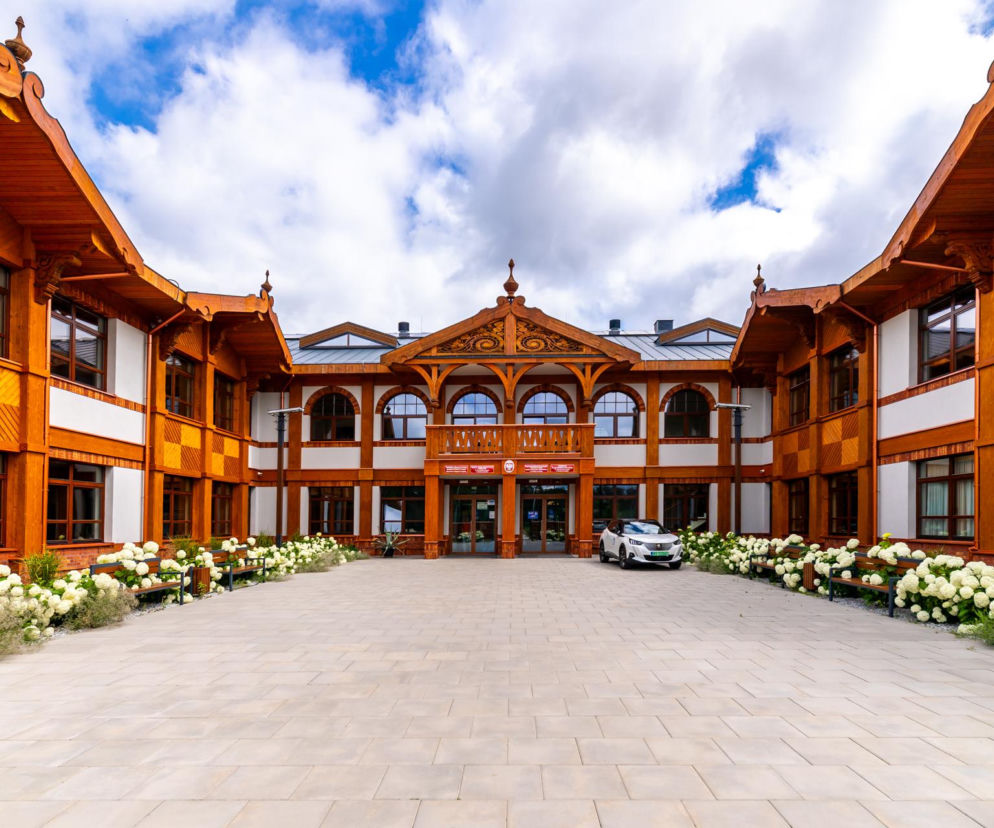 Dziedziniec Szkoły Drzewnej w Garbatce-Letnisku z ozdobnymi, drewnianymi fasadami. O tej architekturze czytaj na Architektura.
