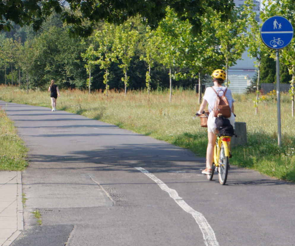 Rowerzystka i piesza na zniszczonej ścieżce przy al. Sikorskiego. O opóźnieniach w inwestycji przeczytasz na Eska Warszawa.