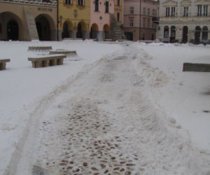 Rynek w Tarnowie pod śniegiem. W akcji pługopiaskarka MPGK
