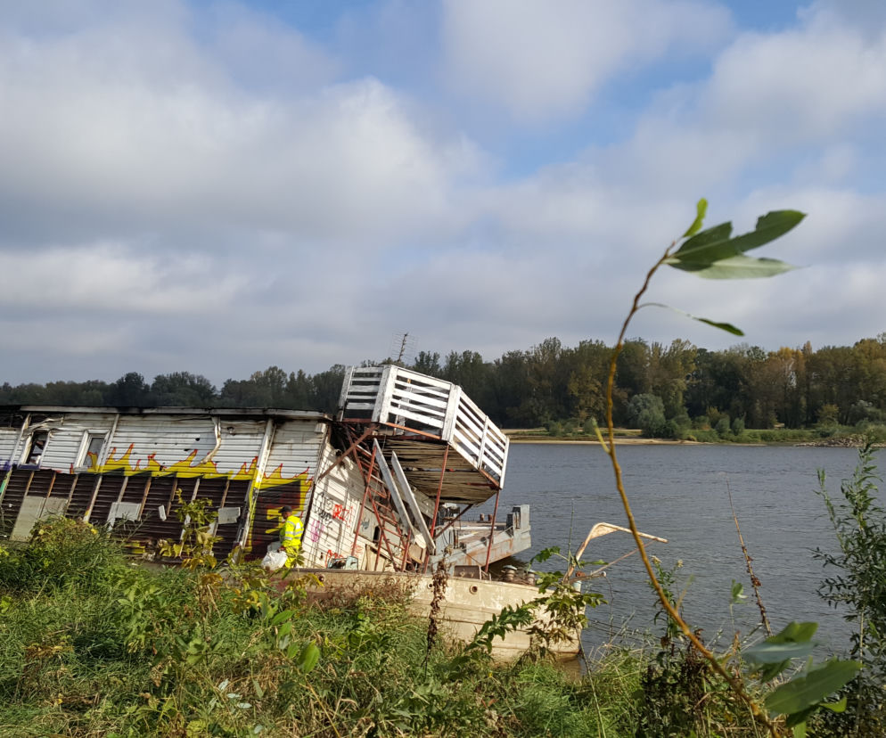 Robotnicy rozbierają konstrukcję barki