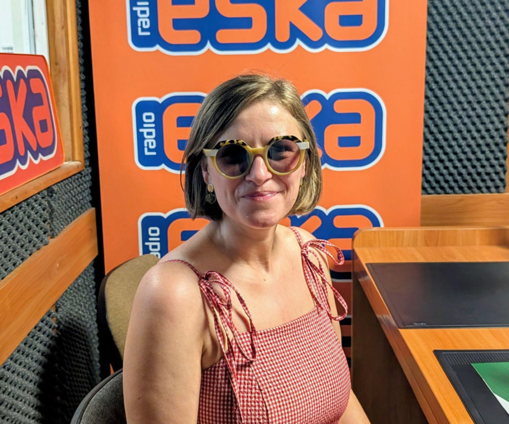 Uśmiechnięta kobieta w okularach przeciwsłonecznych w studio radiowym. O kinowych planach na lato czytaj na Eska Tarnów.