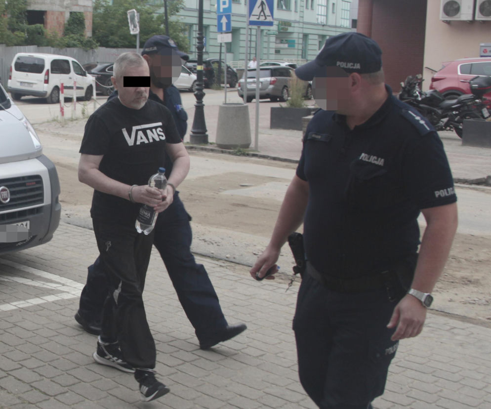 Policjanci prowadzą oskarżonego Adama C. w kajdankach. O procesie w sprawie zabójstwa ratownika pisze Eska Warszawa.