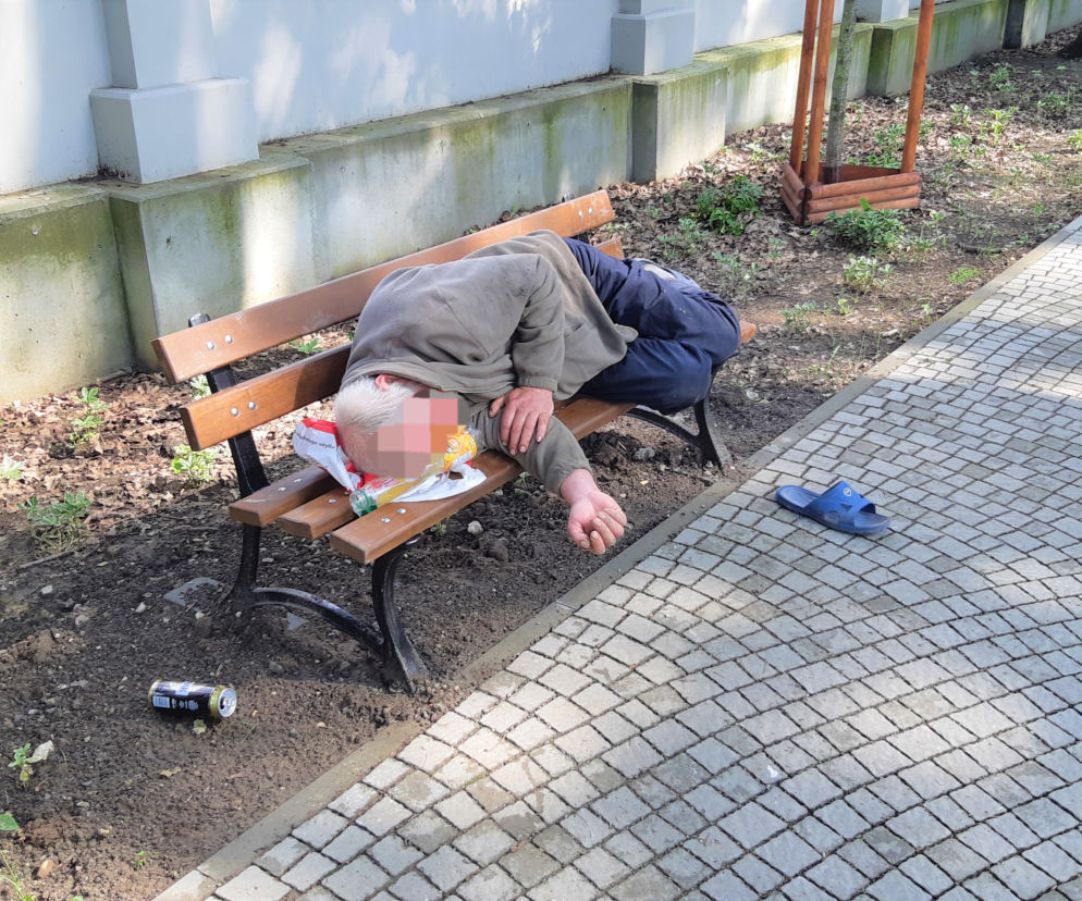 Bezdomny leży na ławce