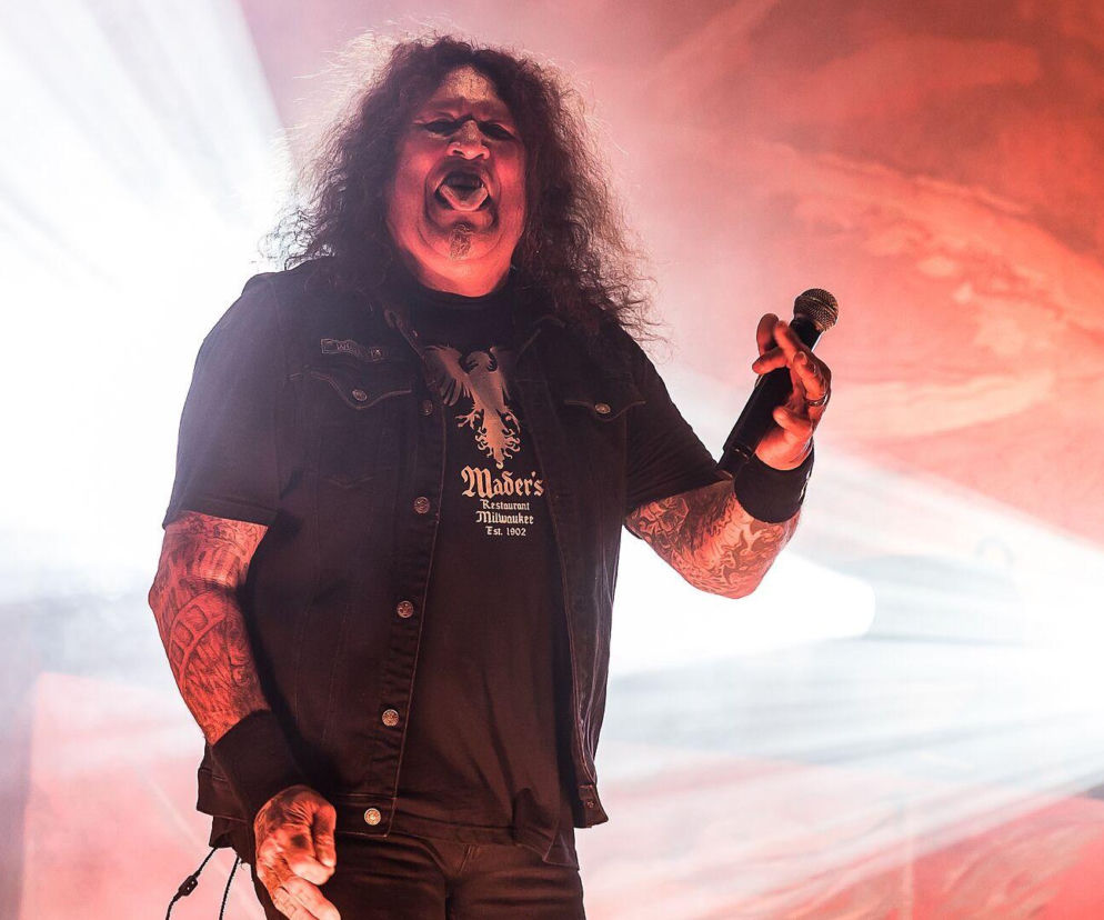 Chuck Billy z zespołu Testament śpiewa do mikrofonu na scenie. O walce muzyka z chorobą przeczytasz na EskaRock.