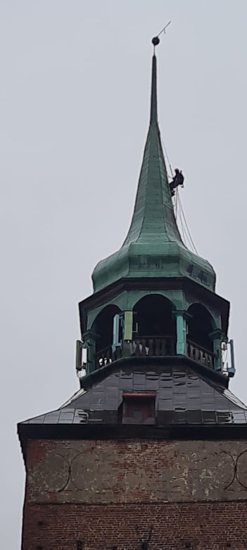 Alpinista na wieży kościoła w Białogardzie