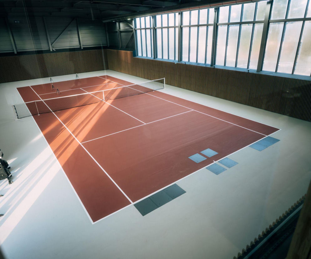 Nowoczesne, zadaszone laboratorium tenisowe ASICS, wyposażone w kort o parametrach turniejowych i sprzęt badawczy, służące do analizy biomechaniki ruchu sportowców. Więcej o innowacjach przeczytasz na Super Biznes.