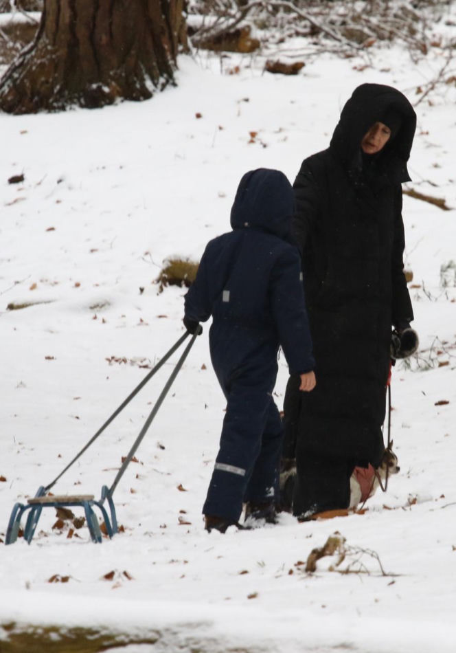 Marta Kaczyńska z synem i psami na sankach w lesie