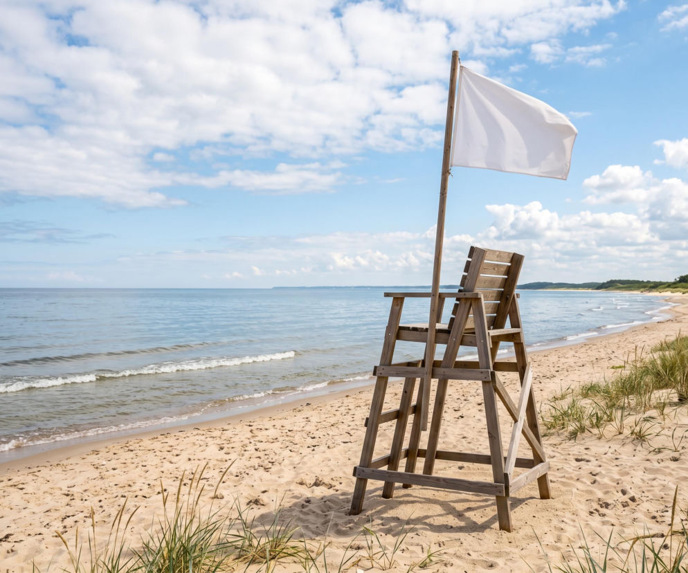 Drewniana wieżyczka ratownika z białą flagą na piaszczystej plaży. O pogodzie w Mechelinkach czytaj na Eska Trójmiasto.