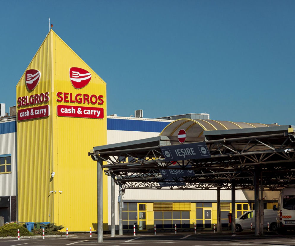Zewnętrzny widok na sklep Selgros cash & carry z żółto-czerwonym logo na tle niebieskiego nieba, symbolizujący koniec działalności e-sklepu i koncentrację na handlu stacjonarnym. Więcej o zmianach strategii Selgros przeczytasz na Super Biznes.