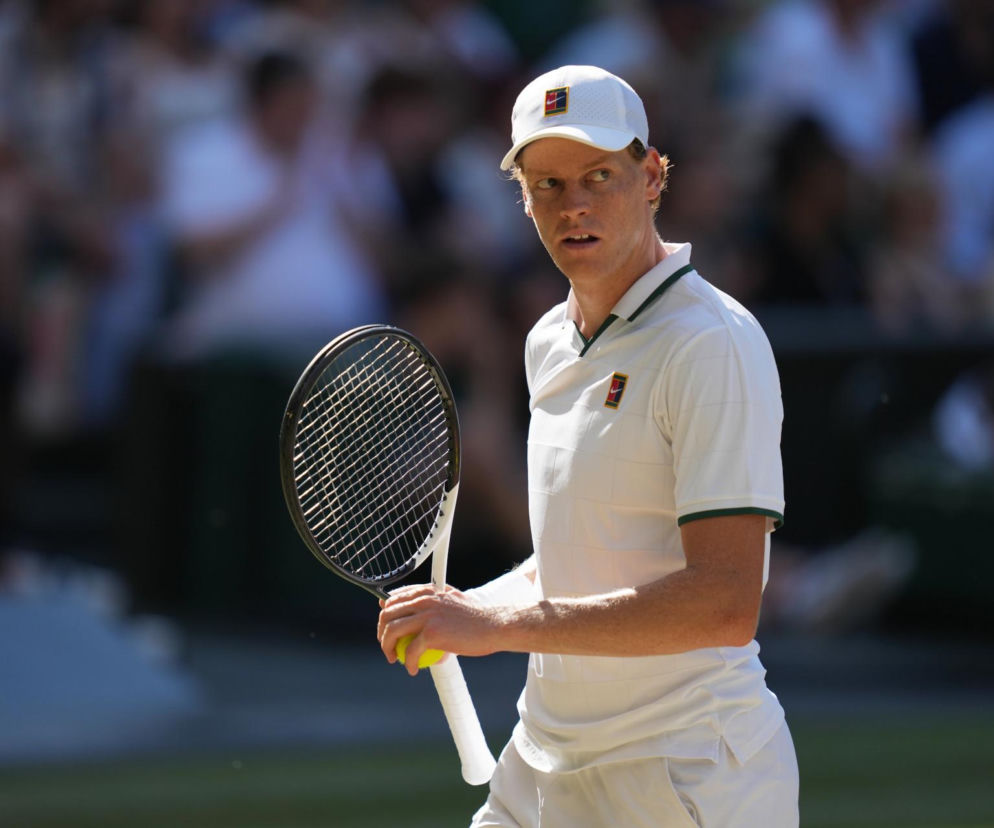 Tenisista Jannik Sinner w białym stroju trzyma rakietę na korcie. O jego rezygnacji z US Open przeczytasz na SE Supersport.