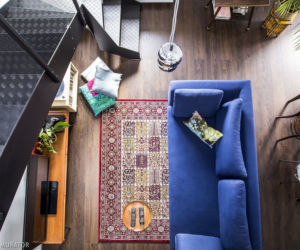 Granatowa sofa  na orientalnym dywanie w salonie
