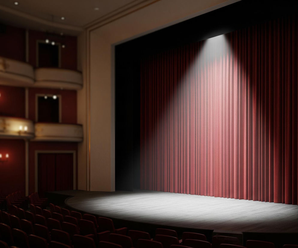 Centralnym punktem obrazu jest pusta scena teatralna, oświetlona silnym, białym reflektorem z góry, rzucającym owalne światło na drewnianą podłogę. Za sceną widnieje ciemnoczerwona, pofałdowana kurtyna. Po lewej stronie obrazu rozciąga się widownia z rzędami pustych, czerwonych foteli, a powyżej nich znajdują się balkony z eleganckimi balustradami i przyciemnionymi lampami ściennymi. Całość utrzymana jest w ciemnej, stonowanej kolorystyce z dominacją czerwieni i czerni, podkreślającymi dramatyczny nastrój.