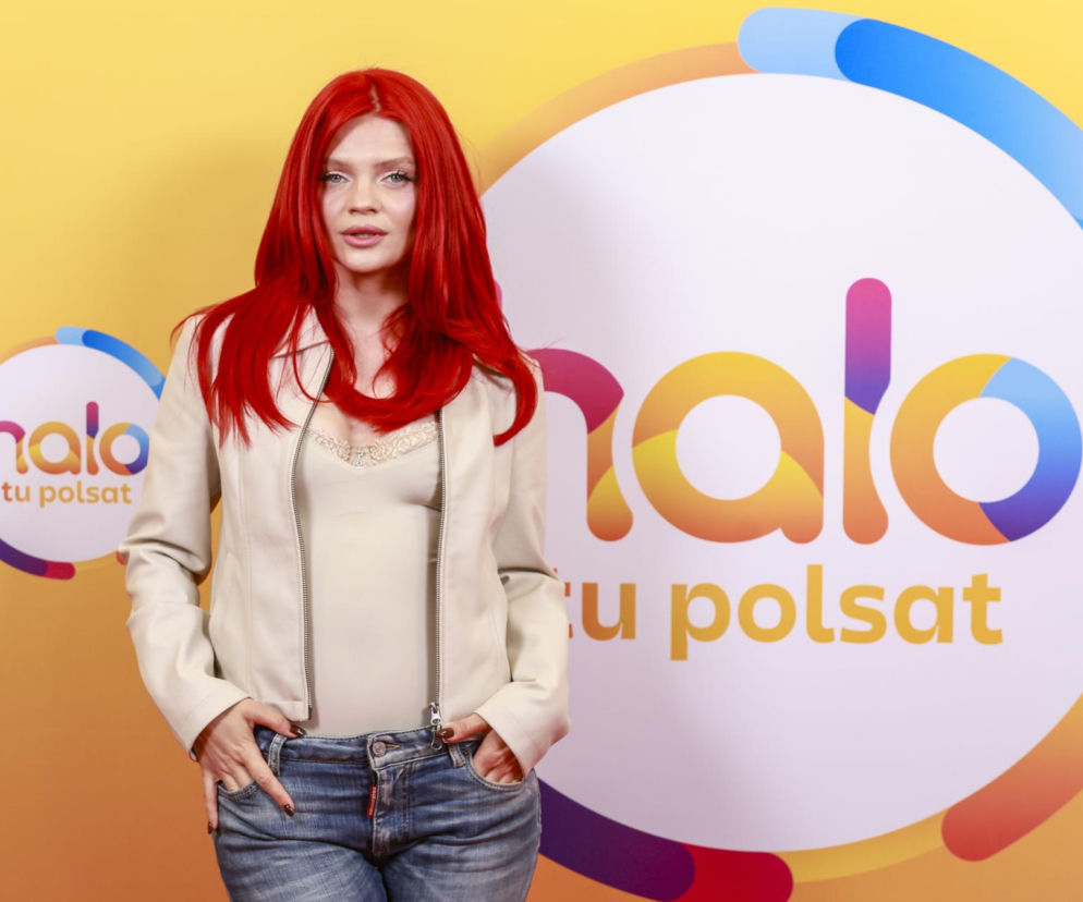 Piosenkarka Małgorzata Jamroży, znana jako Margaret, z ognistoczerwonymi włosami i w jasnej kurtce, pozuje na tle logotypu Halo tu Polsat. Ta współczesna stylizacja artystki świadomie łamiącej konwenanse jest jedną z wielu, o których przeczytasz na naszym portalu.