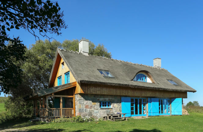 Tradycja w pełnej krasie - kamień i drewno na ścianach i strzecha na dachu