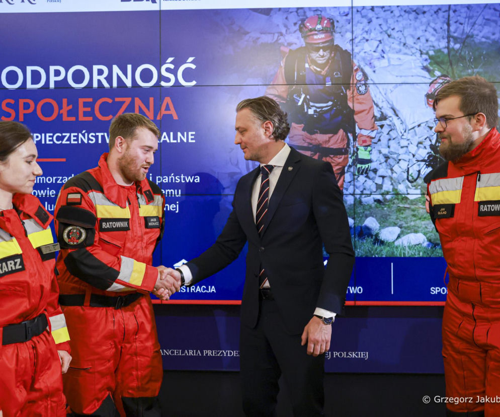Bartosz Grodecki podaje rękę ratownikowi podczas konferencji BBN. O szczegółach przeczytasz na SE Portal Obronny.