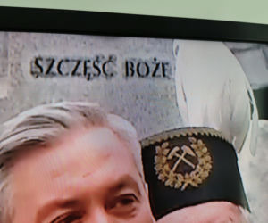 Robert Biedroń na tle religijnego hasła