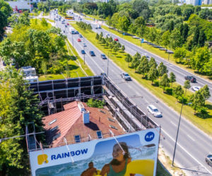 Otoczony reklamami dom przy Dolinie Służewieckiej w Warszawie