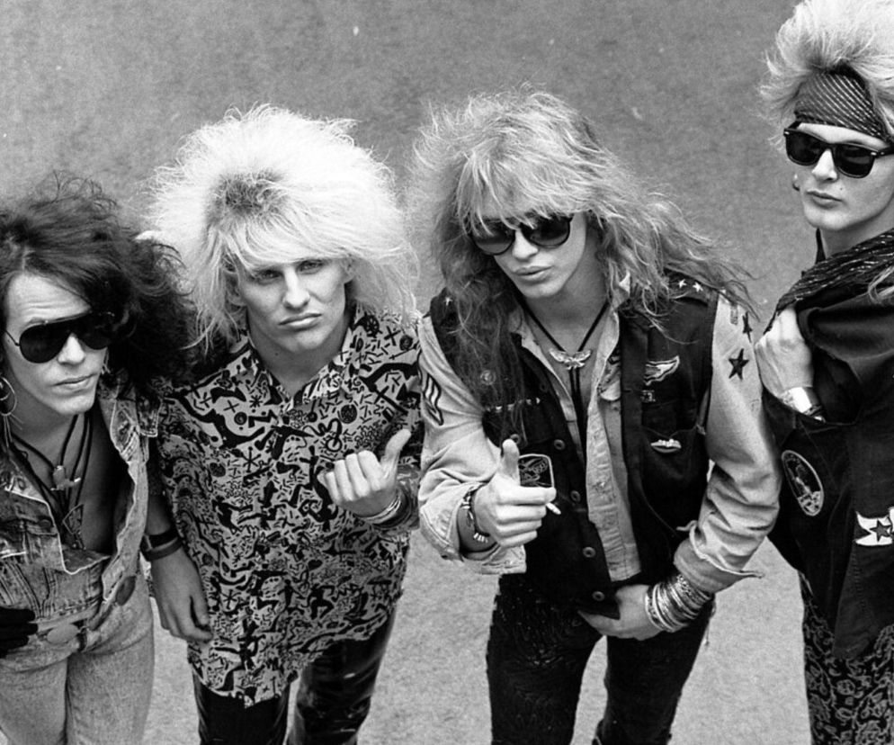 Muzycy zespołu Poison z natapirowanymi włosami w okularach przeciwsłonecznych. O glam metalu przeczytasz na EskaRock.