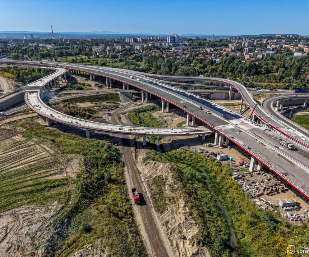 Węzeł Mistrzejowice w budowie widziany z góry. Estakady nad torami i domy w tle. O postępach prac pisze Architektura.