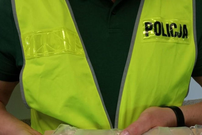 Tułów policjanta w odblaskowej kamizelce z napisem Policja. O incydencie w olsztyńskiej szkole czytaj w Eska Olsztyn.