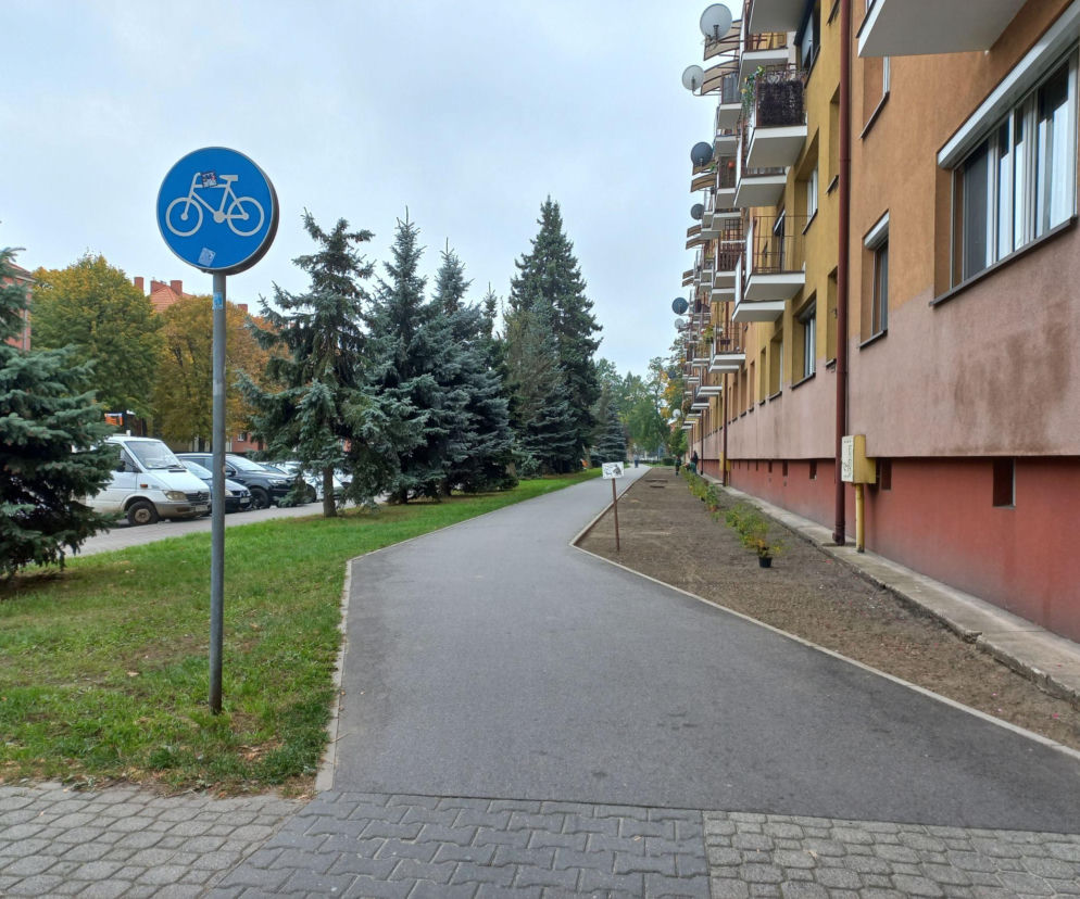 Chodnik wzdłuż bloku przy ul. Dąbrowskiego w Lesznie i pas ziemi pod nowe rośliny. O zmianach przeczytasz na Eska Leszno.
