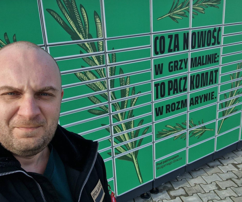 Mężczyzna z zarostem na tle zielonego Paczkomatu InPost ozdobionego rozmarynem i napisem o nim, który stał się marketingowym złotem w Grzymalinie. Całą historię, jak InPost zamienił prośbę w marketingowe złoto, przeczytasz na Super Biznes.