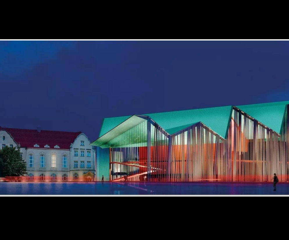 Wizualizacja nowej siedziby Teatru Muzycznego w Poznaniu nocą. Widoczny budynek z przeszklonymi elewacjami i zielonym dachem, otoczony światłami, co doskonale ilustruje przyszłą architekturę, o której przeczytasz na Architektura Murator Plus.