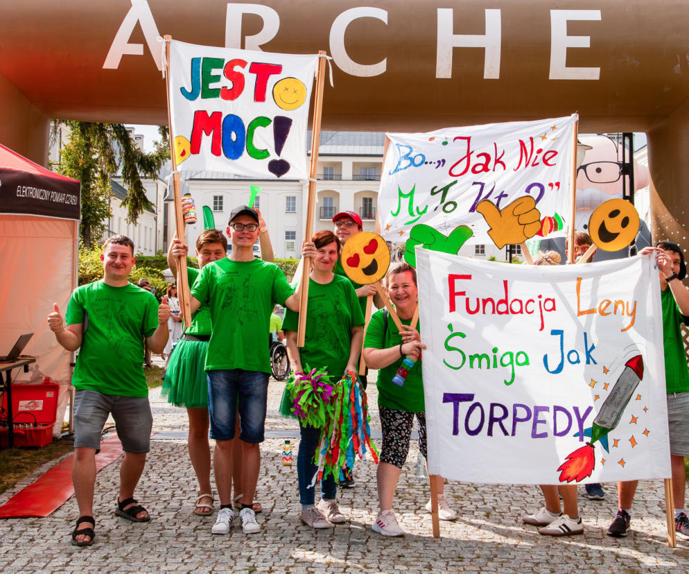 Uśmiechnięci wolontariusze w zielonych koszulkach z transparentami Fundacji Leny Grochowskiej. Więcej na Eska Siedlce.