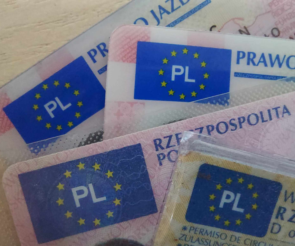 Kilka blankietów polskiego prawa jazdy z oznaczeniem PL i gwiazdkami UE na niebieskim tle. Artykuł na Super Biznes informuje o zmianach w przepisach i punkach karnych, które uderzą w kierowców.