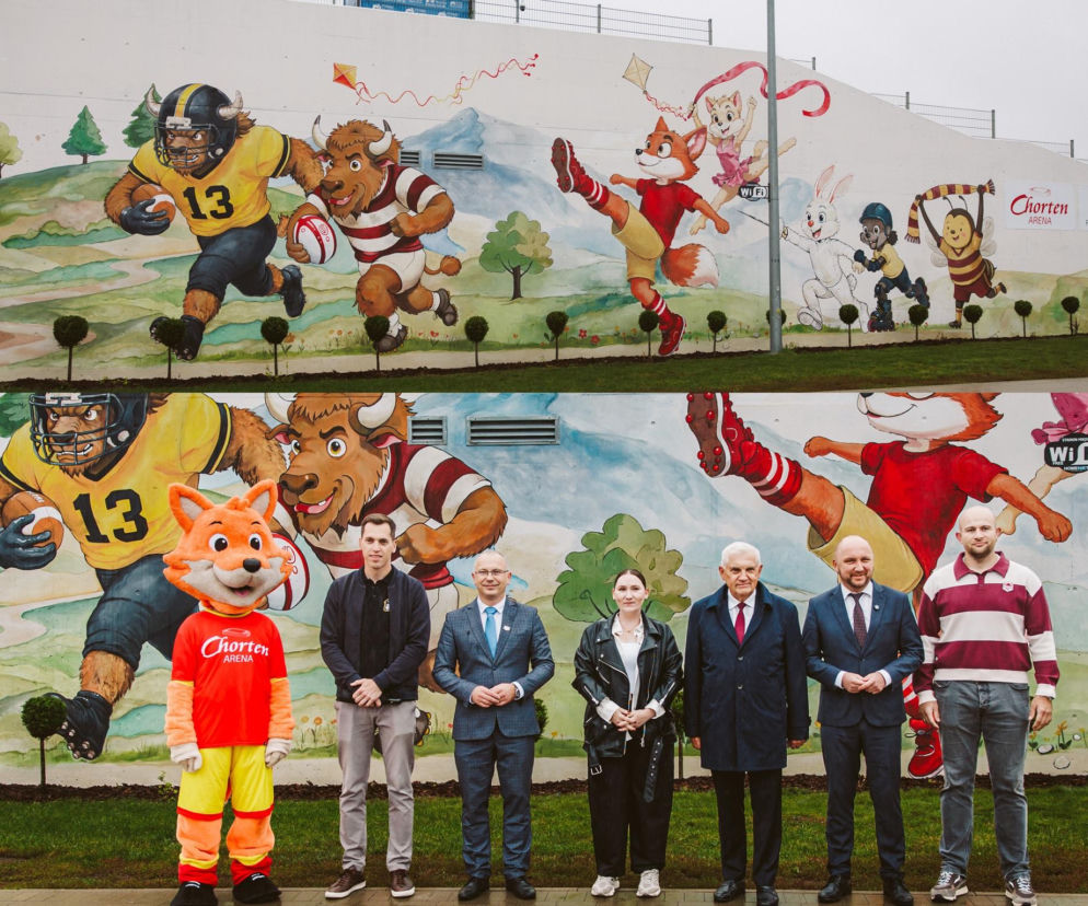 Mural ze sportowymi maskotkami na Chorten Arenie. Przed nim stoją oficjele. O nowej ozdobie przeczytasz na Eska Białystok.