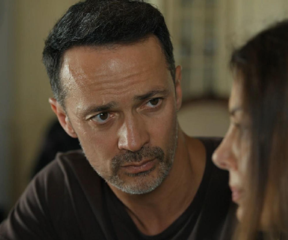 Aktor Rafał Cieszyński w roli Mariusza w serialu Barwy szczęścia rozmawia z Kasią, graną przez Katarzynę Glinkę. Mariusz ma zmartwioną minę. Scena dotyczy problemów w ich związku, o których można przeczytać na Super Seriale.