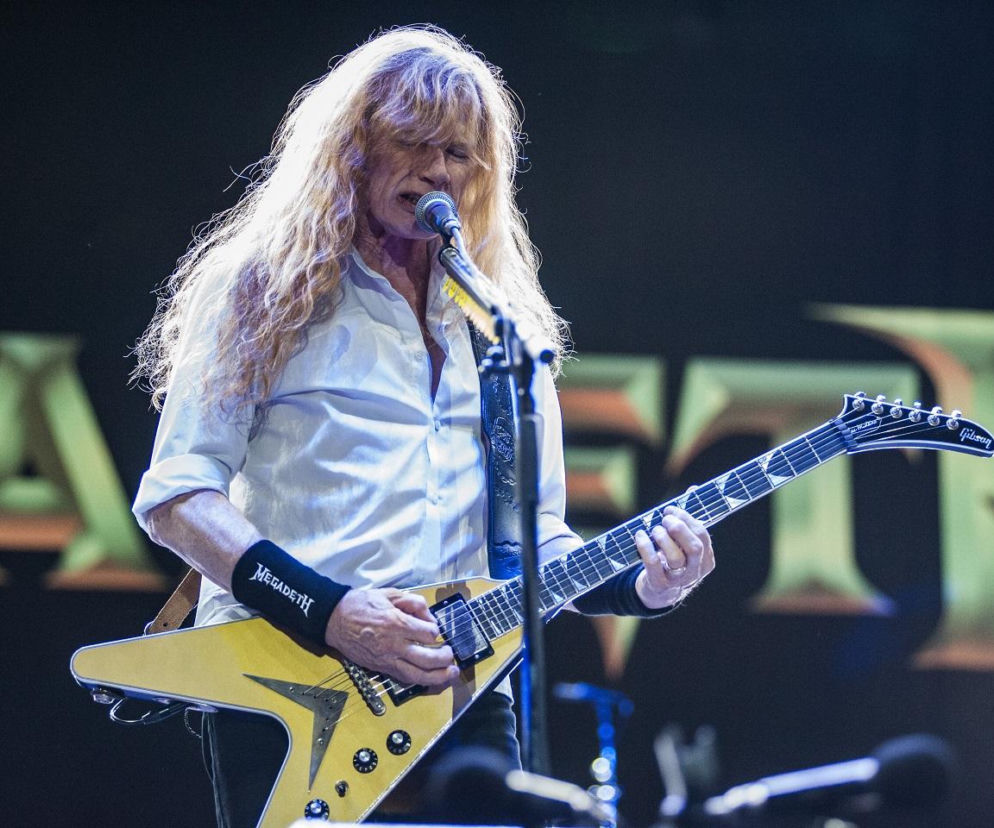 Dave Mustaine gra na gitarze elektrycznej i śpiewa do mikrofonu podczas koncertu Megadeth. Czytaj więcej w EskaRock.