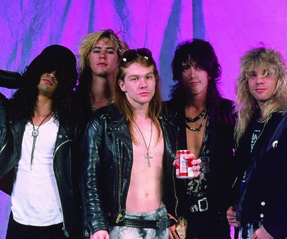 Muzycy zespołu Guns N' Roses na tle fioletowej płachty. O kulisach klipu Sweet Child O' Mine przeczytasz na EskaRock.