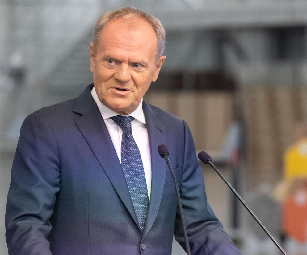 Premier Donald Tusk przemawia przy mikrofonach. O jego reakcji na rosyjski atak przeczytasz na SE Polityka.