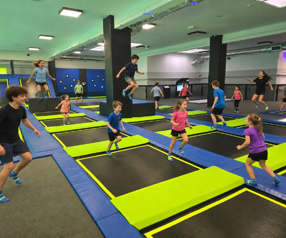 Dzieci skaczą na trampolinach w nowoczesnym parku rozrywki. O atrakcjach w Starachowicach przeczytasz na Eska Starachowice.