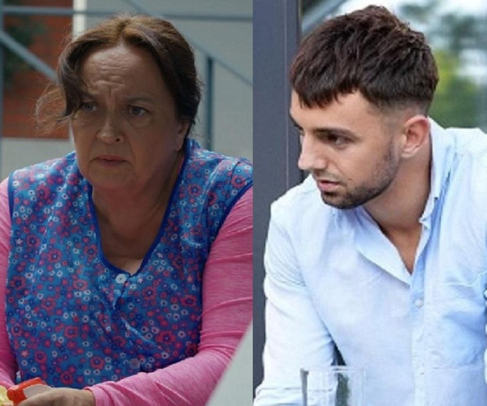 Bogusia (Halina Bednarz) w różowej bluzce i fartuchu w kwiaty, z zagniewaną miną, oraz Mirek (Oliwier Kozłowski) w jasnoniebieskiej koszuli, patrzący w bok. Zdjęcie ilustruje fatalne zachowanie Mirka wobec Bogusi w serialu Barwy szczęścia, o czym przeczytasz na portalu Super Seriale.