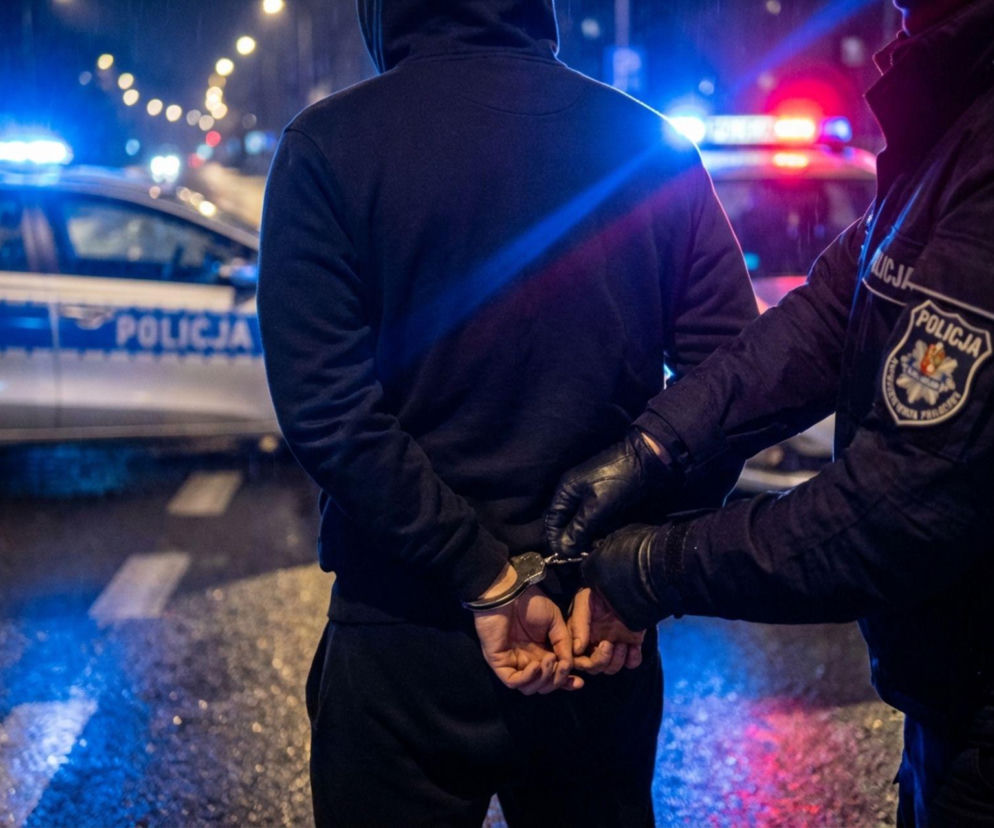 Policjant zakładający kajdanki zatrzymanemu