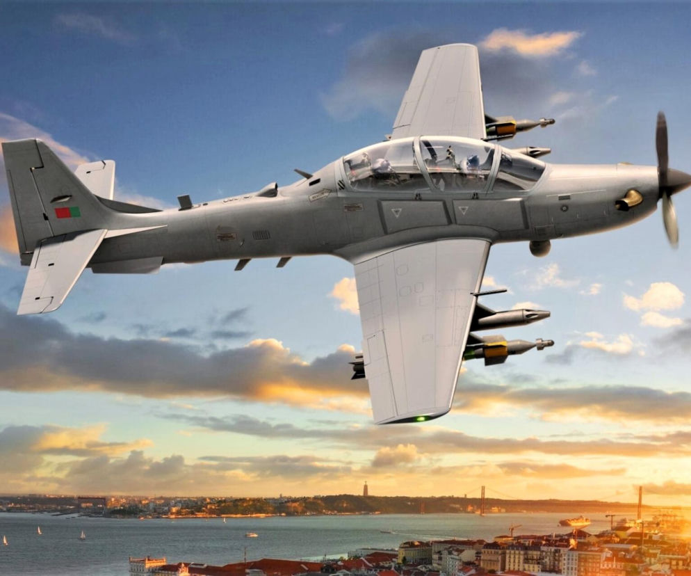 Lekki samolot bojowy A-29 Super Tucano w locie nad miastem. O planach zakupu maszyn przez Łotwę pisze SE Portal Obronny.