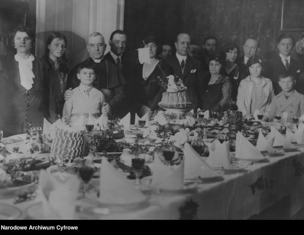 Uczestnicy spotkania Wielkanocnego przy zastawionym świątecznymi potrawami stole (1931)