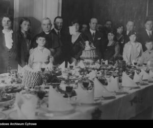 Uczestnicy spotkania Wielkanocnego przy zastawionym świątecznymi potrawami stole (1931)