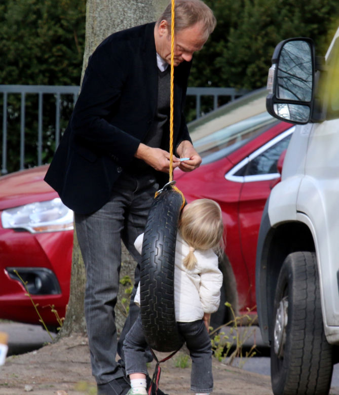Donald Tusk z wnuczka na placu zabaw