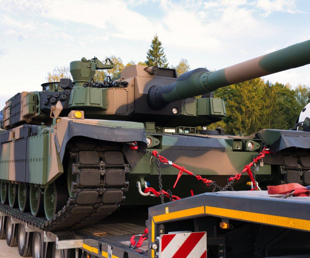 Czołg K2 Black Panther przypięty czerwonymi łańcuchami do naczepy ciężarówki. O nowej dostawie pisze SE Portal Obronny.