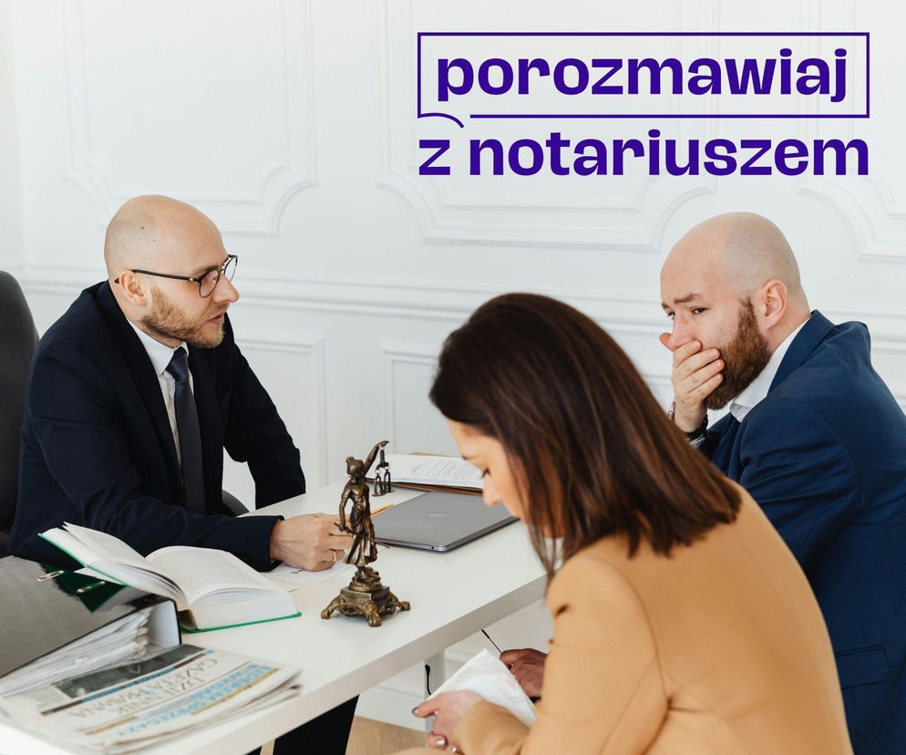 Trzy osoby przy stole: notariusz w garniturze rozmawia z klientem, który zakrywa usta dłonią, oraz klientką. Na blacie laptop, akta i figurka Temidy. O Dniu Otwartym Notariatu i bezpłatnych poradach prawnych czytaj na Super Biznes.