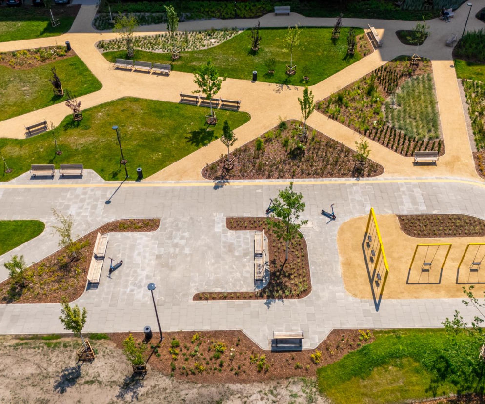 Widok z góry na ukończone alejki, ławki i żółte huśtawki parku nad POW. O finale prac przeczytasz w Architektura.