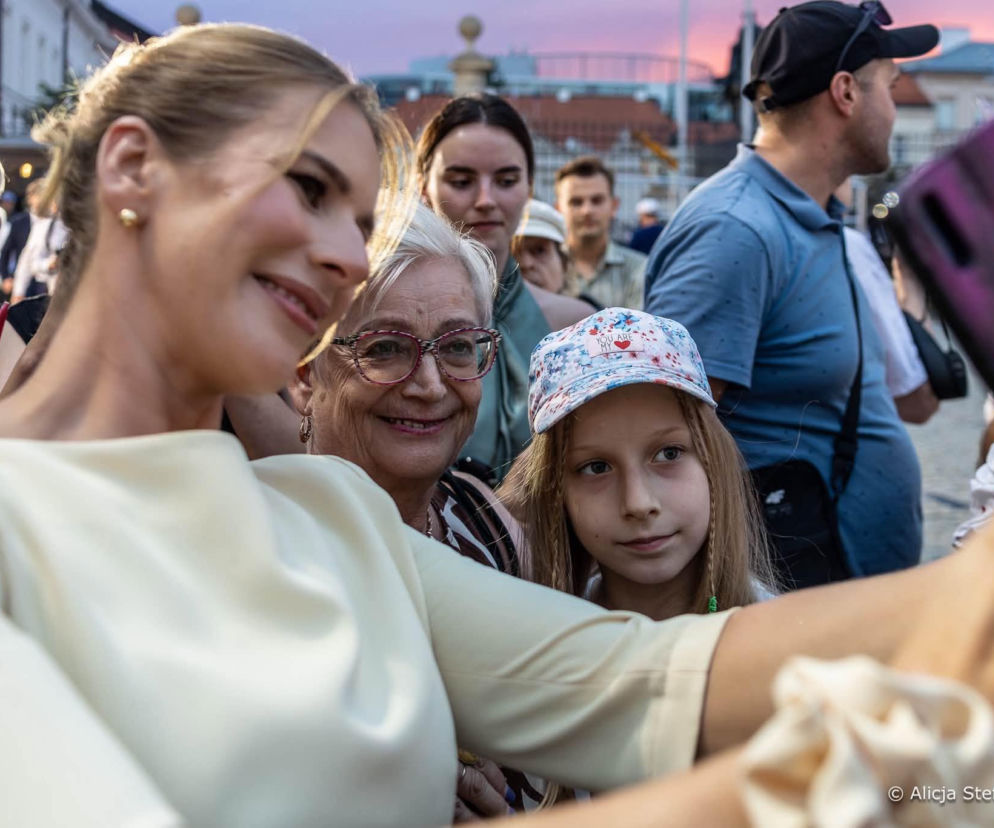 Marta Nawrocka robiąca selfie z uśmiechniętą seniorką i dzieckiem. O sondażach pierwszej damy przeczytasz na Eska.