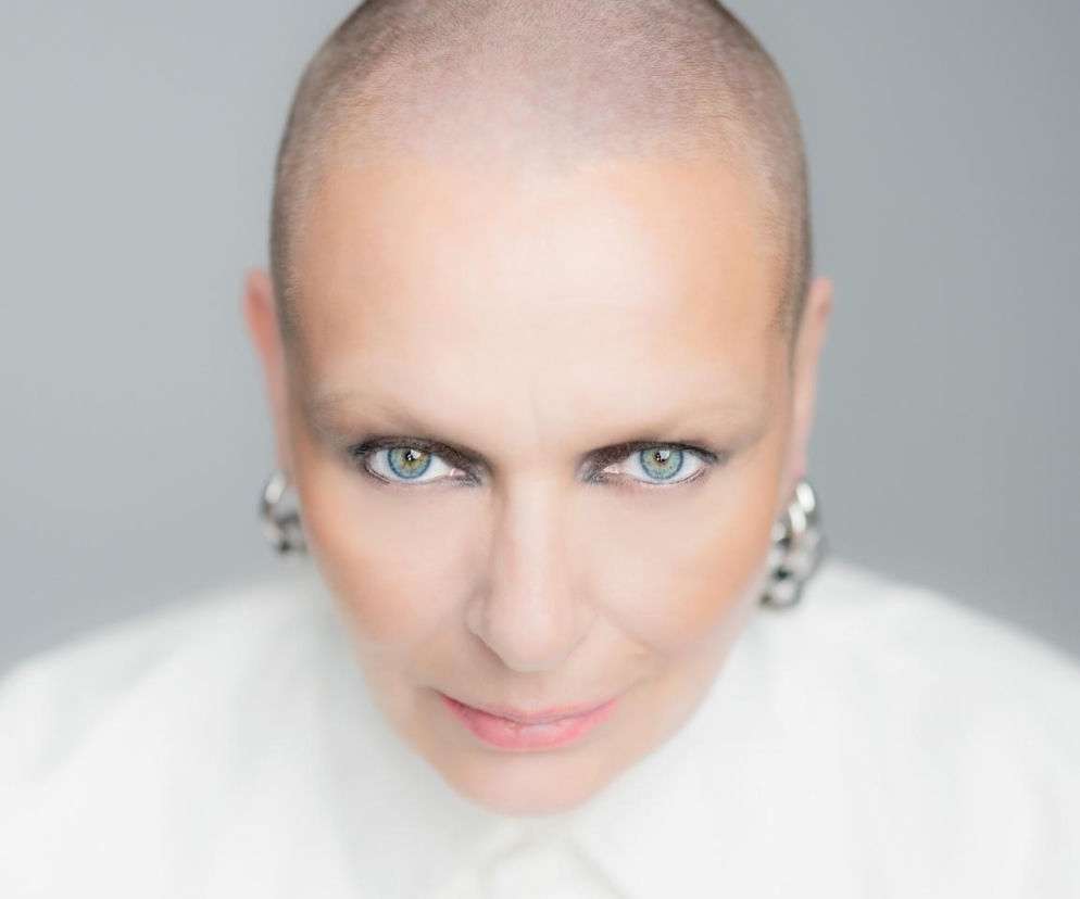 Katarzyna Nosowska z ogoloną głową i w srebrnych kolczykach. O nowym albumie Nigredo przeczytasz na EskaRock.